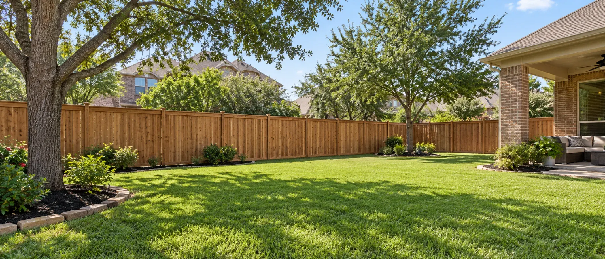 Illustration of a wood privacy fence around a large backyard with a shade tree and covered patio